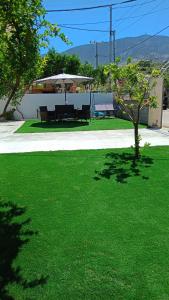 a green lawn with a table and an umbrella at villa by the sea in Kato Alepochori +15 photos