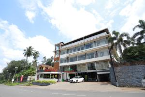 a white car parked in front of a building at Aroma Ayur Heritage in Mattanūr