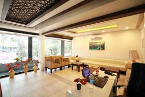 a living room with a couch and a desk with a laptop at Aroma Ayur Heritage in Mattanūr