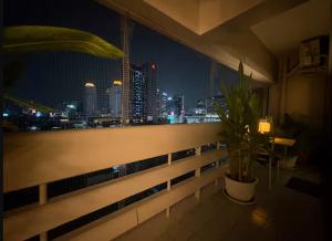 a balcony with a view of a city at night at Cozy 1br walk to BTS and Airport Rail Link Close to Malls T in Bangkok
