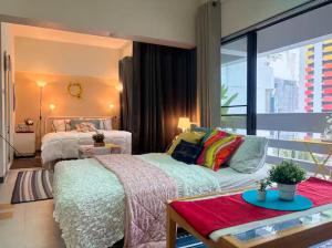 a bedroom with two beds and a large window at Cozy 1br walk to BTS and Airport Rail Link Close to Malls T in Bangkok +193 photos