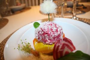 a white plate with a doughnut with pink and white sprinkles at ApartamentyDiana in Pogórze