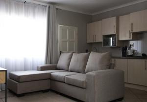 a living room with a couch and a kitchen at Tubalala Properties in Rustenburg +73 photos