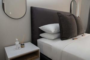 a bedroom with a bed with a mirror and a side table at Tubalala Properties in Rustenburg