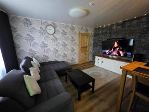 a living room with a couch and a flat screen tv at Green- Guest Apartment- Tapa in Tapa
