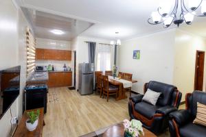 a living room with a kitchen and a dining room at SereneKey Stays in Kigo