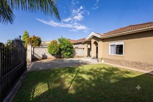 a house with a fence and a yard at SereneKey Stays in Kigo