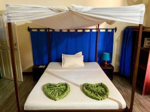 a bedroom with a bed with two hearts on it at Hotel Le Petit Paradis in Antsiranana