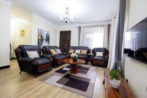 a living room with leather chairs and a table at SereneKey Stays in Kigo