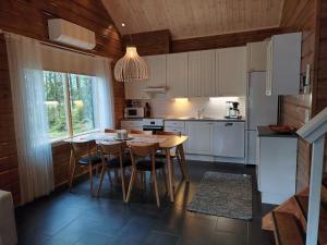 a kitchen with a table and chairs in it at Villa Goahti - Kantokelo in Ylläsjärvi