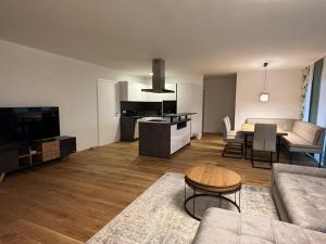 a living room with a couch and a table and a kitchen at Panorama-Lodge Mittagskogel in Ledenitzen +6 photos