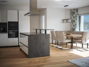 a kitchen and dining room with a table and chairs at Panorama-Lodge Mittagskogel in Ledenitzen