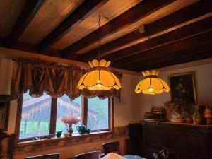 two chandeliers in a dining room with a window at Wine and roses farm house in Waymart