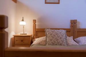 a bedroom with a bed with a lamp on a night stand at Penzion Vinicky dvůr in Kaplice