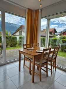a dining room with a table and chairs and large windows at Alpine Bliss Studio in Wilderswil +8 photos