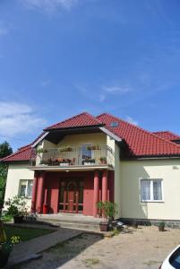 a house with a red roof and a balcony at Moka in Grzybowo