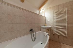a bathroom with a tub and a sink at Penzion Vinicky dvůr in Kaplice