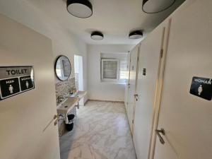 a bathroom with a hallway with a sink and a mirror at Hostel P16 in Zagreb