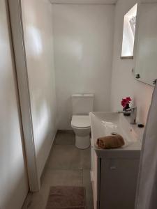 a white bathroom with a toilet and a sink at Pé na Praia in Torres Vedras