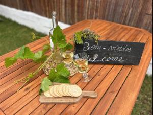 a table with two glasses of wine and a sign at Pé na Praia in Torres Vedras