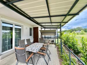 a patio with a table and chairs on a deck at Silver Lux Apartman in Sárvár