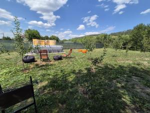 a field with two chairs and an apple tree at The Nest Room in Bontida