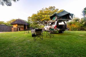 a truck parked in a yard with a tent on it at Hakusembe River Campsite in Rundu