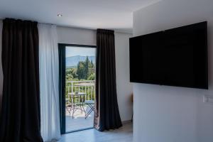 a living room with a flat screen tv and a balcony at Matej's rooms in Korčula