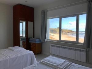 a bedroom with two beds and a view of the ocean at Apartagal- Casa Playa, Foz in Foz