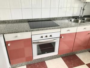 a kitchen with a stove and a sink at Apartagal- Casa Playa, Foz in Foz