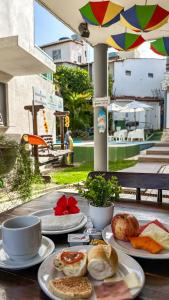 a table with plates of food and a cup of coffee at Pousada Porto Amazônia in Porto De Galinhas