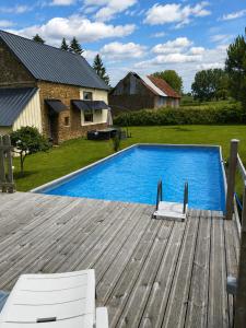 a swimming pool on a wooden deck next to a house at gite "La Renaudaie" - piscine in Juvigny-le-Tertre +16 photos