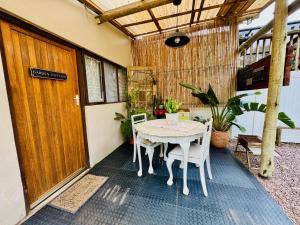 a porch with a table and chairs and a door at The Boshoff in Durban