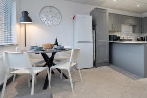 a kitchen with a table and chairs and a refrigerator at Open Mind Property - Spacious 2BR Flat City Views in Portsmouth
