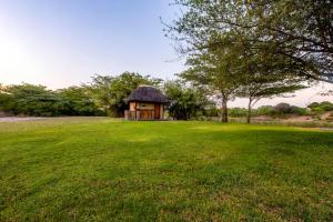 a small hut in a field with a grass field at Hakusembe River Campsite in Rundu