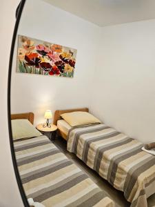 two beds in a room with a mirror at Apartman Ruza 1 in Poljane