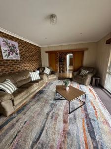 a living room with a couch and a coffee table at Casa Sarina in Stanthorpe