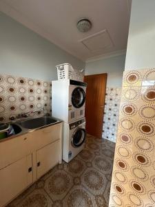 a kitchen with a sink and a washing machine at Casa Sarina in Stanthorpe