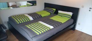two beds in a bedroom with green and gray pillows at Gemütliche Ferienwohnung in Essen
