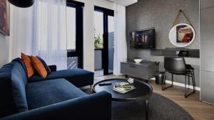 a living room with a blue couch and a table at Century City Hotel Bridgewater in Cape Town