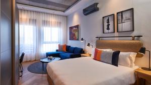 a bedroom with a bed and a blue couch at Century City Hotel Bridgewater in Cape Town