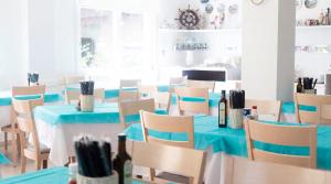 a dining room with blue tables and chairs with bottles of wine at Brasilia Sweet Home in Cesenatico