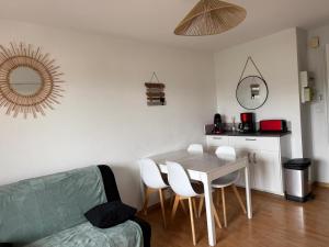 a living room with a table and a couch at T2, accès direct plage, proche thalasso in Cabourg