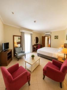 ein Hotelzimmer mit einem Bett und zwei roten Stühlen in der Unterkunft Okaliptus Otel in Bitez
