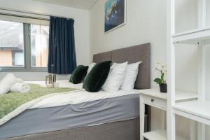 a bedroom with a bed with green and white pillows at Open Mind Property - Spacious 2BR Flat City Views in Portsmouth
