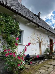 a house with a tree painted on the side of it at Skansen Gottwaldówka in Kąty Bystrzyckie