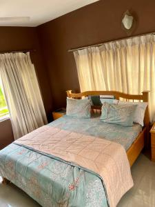 ein Schlafzimmer mit einem Bett mit hölzernem Kopfteil in der Unterkunft Westreams Hotel in New Weija