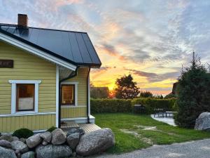 ein kleines Haus mit einem Sonnenuntergang im Hintergrund in der Unterkunft Klaukse in Aabla