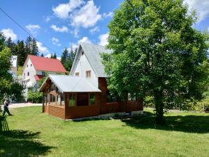 a cabin in a yard next to a tree at Vila Tijana in Žabljak