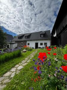 a house with a garden of flowers in front of it at Skansen Gottwaldówka in Kąty Bystrzyckie
